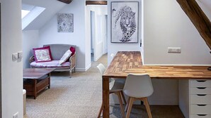Un cuarto acogedor con una cama estilo altiloque, una mesa de comedor de madera con sillas y un ventanal grande.