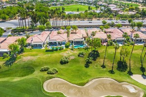Un quartiere residenziale con case, un campo da golf e una piscina.