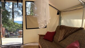 Una habitación acogedora con un sofá, una mesita y vistas al exterior.