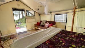 Una habitación con carpa, una cama, un sofá y una ventana.