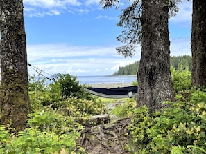 A hammock between trees overlooking a beach. - So Damn Lucky Glamping (Ucluelet)