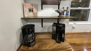 Eine Kaffeestation mit Holzboden, Kaffeemaschinen und einer Kaffeemühle.