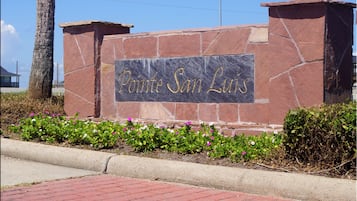 A stone sign with "Pointe San Luis" engraved in gold lettering.