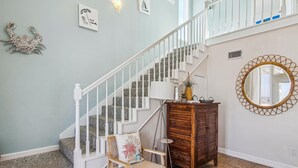 A staircase with white railings and a wooden cabinet with a mirror. - La Dolce Vita (Playa San Luis) by Ryson Vacation Rentals (Galveston)