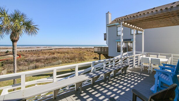 A wooden deck with outdoor seating and a view of the beach. - La Dolce Vita (Playa San Luis) by Ryson Vacation Rentals (Galveston)
