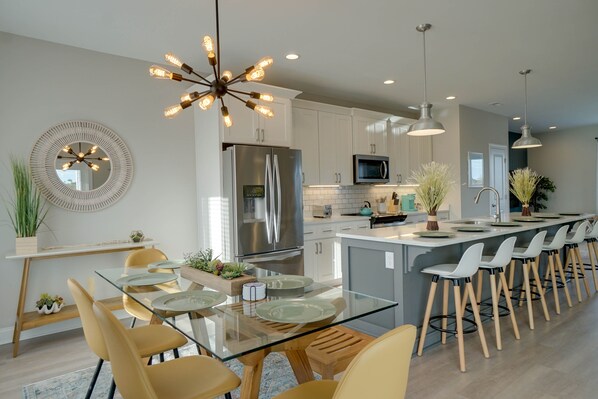 Enjoy cooking in this well-equipped kitchen with a central island, bar stools, and a large mirror.