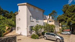 Un bâtiment à deux étages, doté d’un mur en pierre et d’un petit jardin.