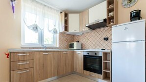 Eine Küche mit Holzausstattung, einer Mikrowelle, einem Backofen und einem Kühlschrank.