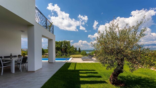 Eine moderne Außenpatio mit Pool, Essbereich und Blick auf die Landschaft.