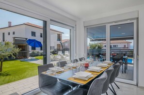 Enjoy meals in this dining area with a view of the outdoor patio and pool.