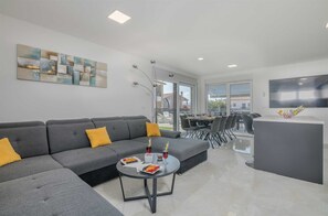 Relax in this stylish living space with a sofa, coffee table, and flat-screen TV.