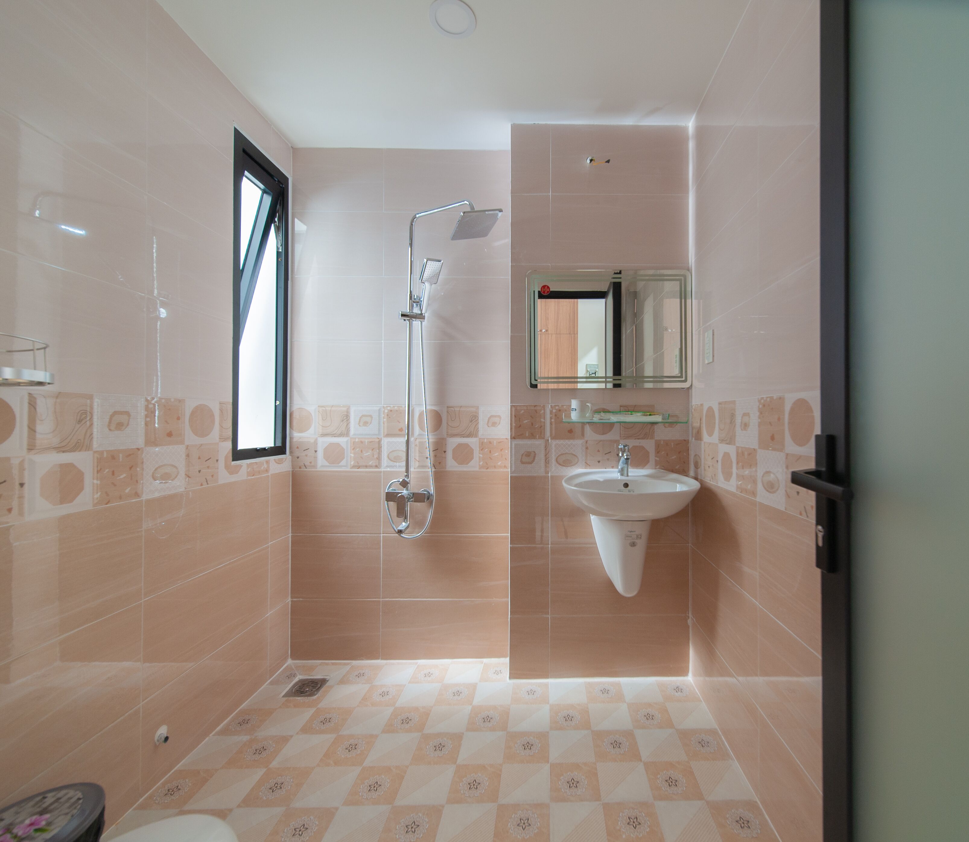 Un baño con ducha, lavamanos y espejo.