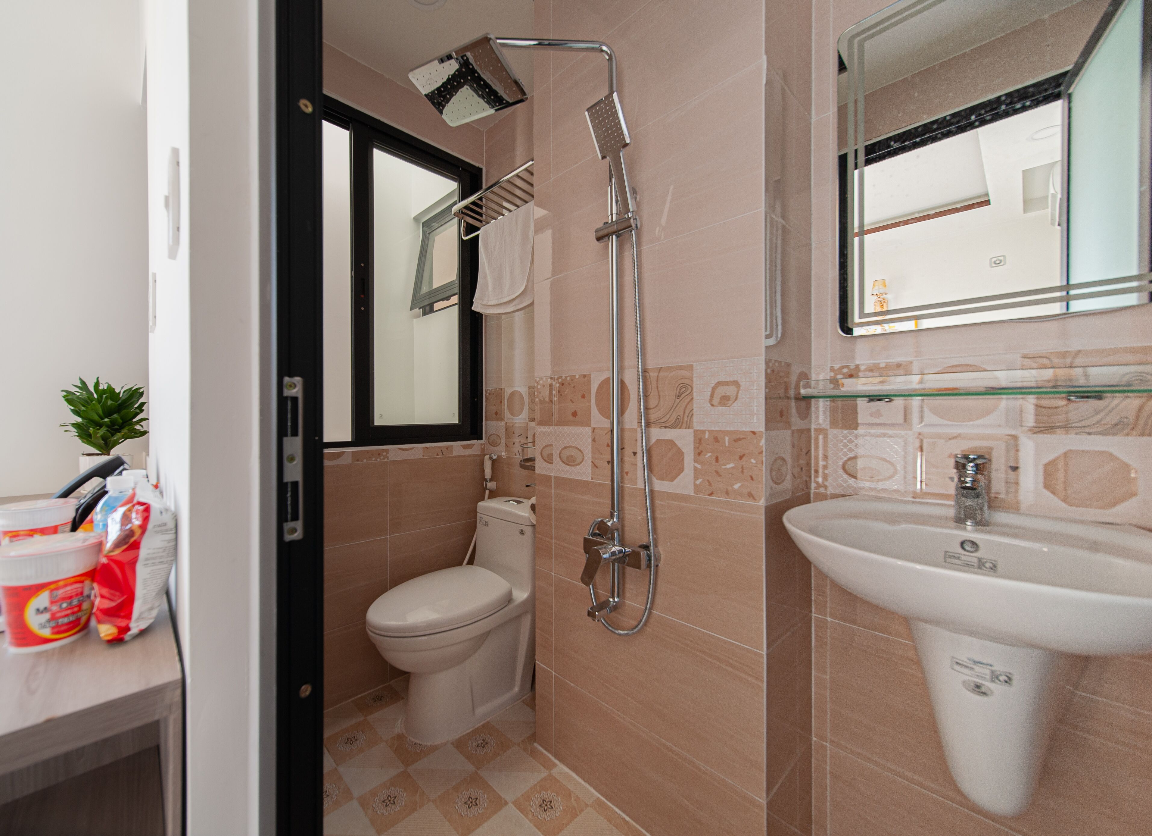 Un baño con inodoro, ducha, lavabo y espejo.