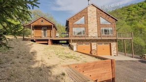 Two wooden cabins with a stone facade, a covered deck, and a gravel driveway. - Buffalo County Log Cabin w Guesthouse and pool (Alma)