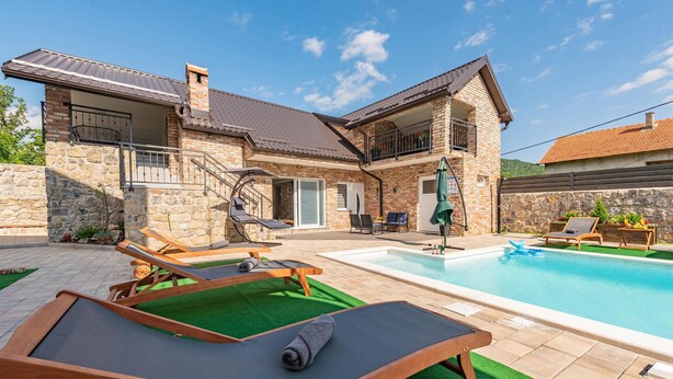 A house with a swimming pool, outdoor seating, and a stone facade. - Amazing apartment in Gracac (Gracac)