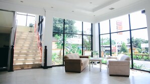 Un salón amplio con ventanas grandes, una escalera y dos sofás.