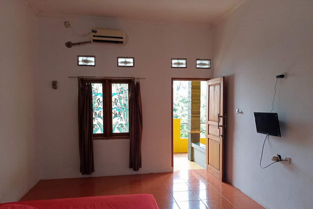 A room with a bed, an air conditioner, a television, and a view of the outside.