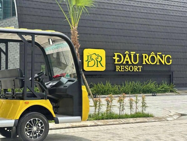 A yellow and black taxi parked in front of a building with a sign that reads "DAU RONG RESORT".