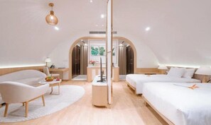 A modern, well-lit bedroom with a large bed, two smaller beds, a desk, and a chair. - Dau Rong Resort (Hai Ha)