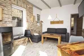 Ein gemütliches Wohnzimmer mit Kamin, einer Couch, einem Couchtisch und einem Fernseher.