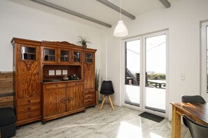 Eine moderne Küche mit Holzschrank, Esstisch und schwarzem Stuhl.