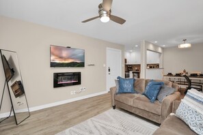 Relax in this stylish living room with a sofa, flat-screen TV, and dining area.