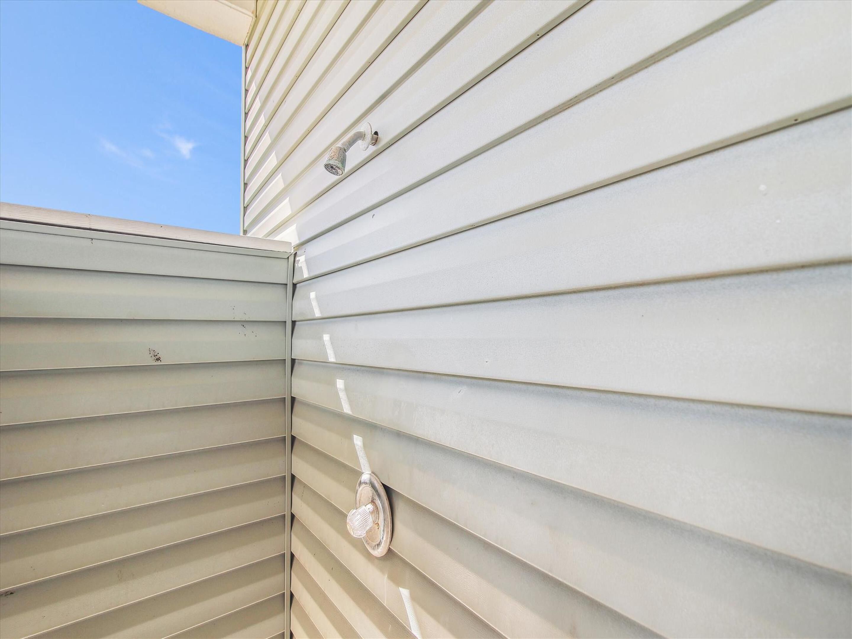 A section of a building with horizontal siding and a visible window with a metal frame.