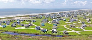 Uma área residencial costeira com casas, ruas e uma praia.