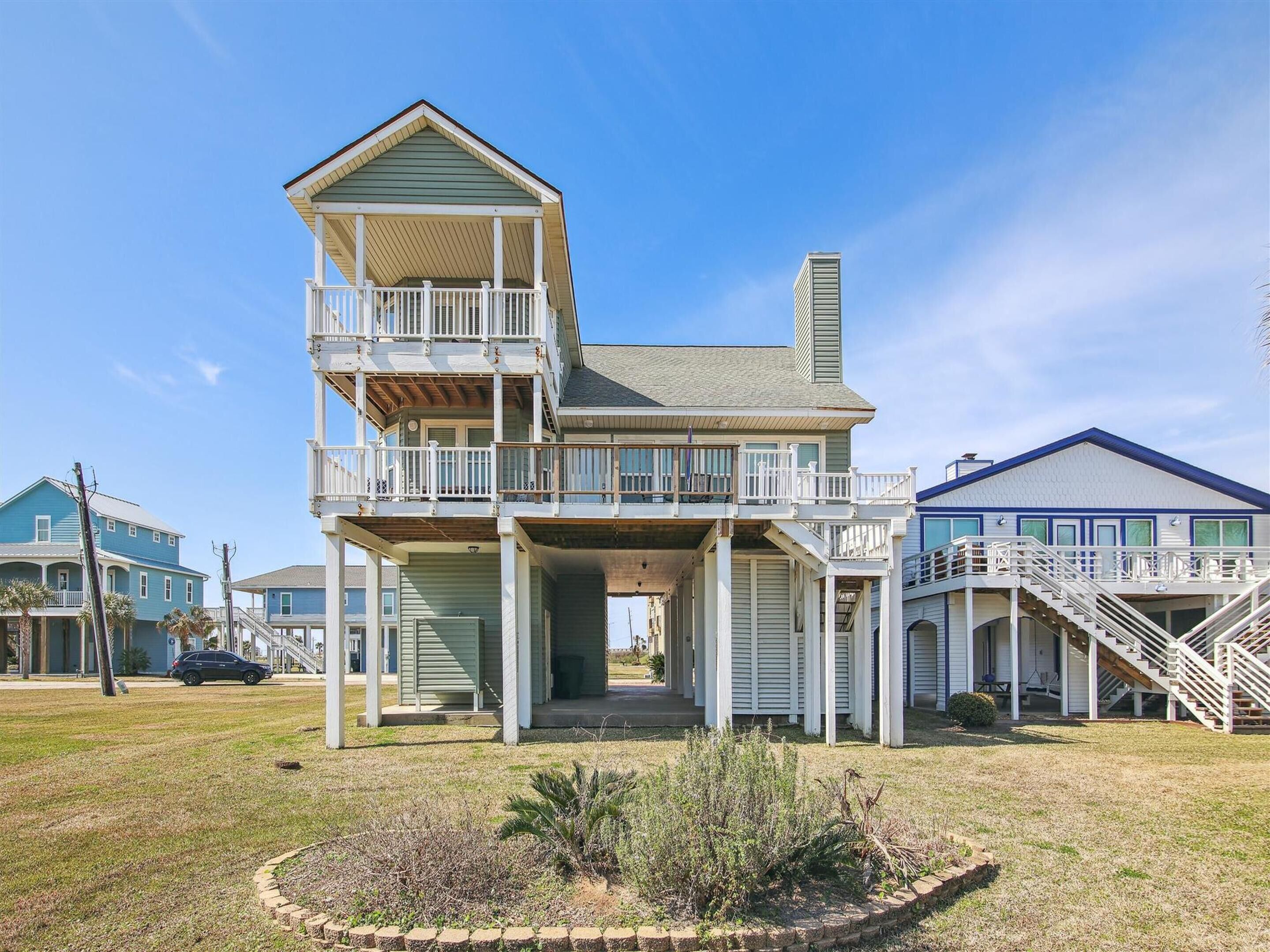A two-story house with a balcony, a covered porch, and a staircase leading to the upper level.