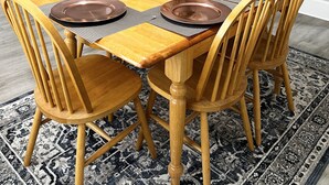 A dining area with a wooden table set for six, surrounded by wooden chairs. - Stanley Cozyside (Middletown)