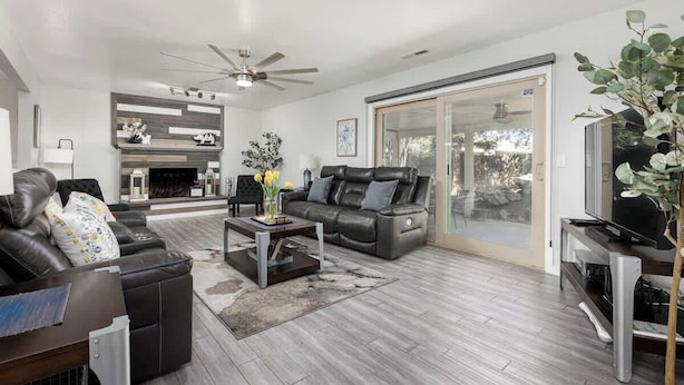 A modern living room with a leather sofa, a coffee table, and a fireplace.