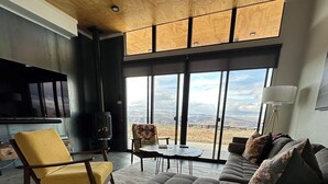 A modern living room with a large window, a sofa, a chair, and a television. - Northwest View Quincy easy walk to Gorge Amphitheater, Cave B Winery, Sagecliffe (Quincy)