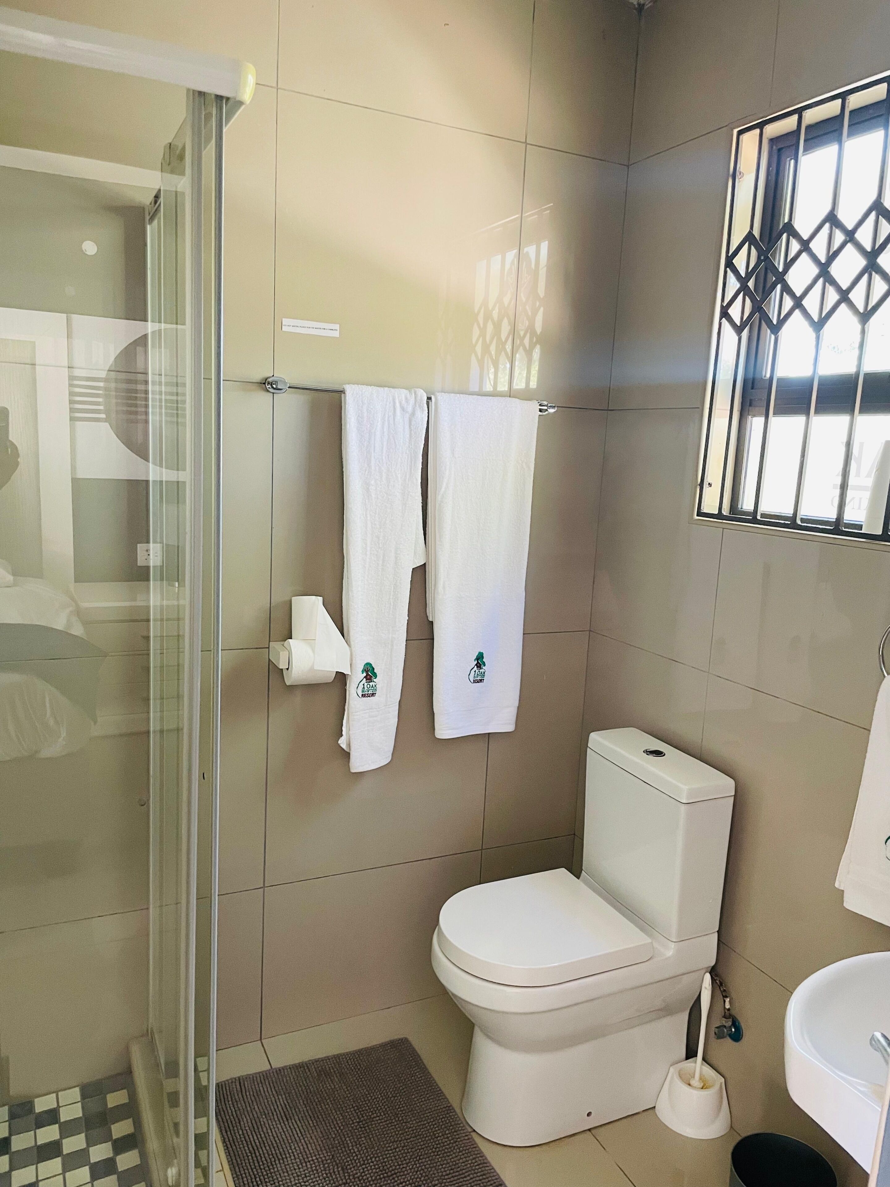 Une salle de bain équipée de toilettes, d’un bidet et d’une douche à parois de verre.