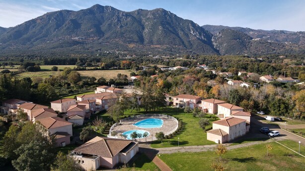 A residential area with houses, a swimming pool, and mountains in the background. - Appartement 2 Piscines, 100m de la Mer, 4/6 Personnes (Santa-Maria-Poggio)