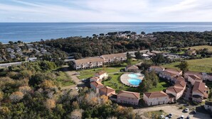 An aerial view of a coastal residential area with multiple apartment buildings, a swimming pool, and a view of the sea. - Appartement 2 Piscines, 100m de la Mer, 4/6 Personnes (Santa-Maria-Poggio)