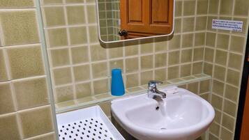 A bathroom with a white sink, a mirror, and a wooden door.