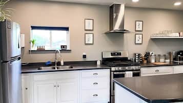 Uma cozinha moderna com armários brancos, eletrodomésticos de aço inoxidável e uma janela com vista.