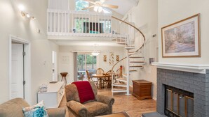 A spacious living room with a high ceiling, a fireplace, a dining area, and a staircase leading to an upper level. - Relax in a Pet-Friendly Lowcountry Home Near Beaches, Downtown Beaufort, and USMC Graduation! (Beaufort)