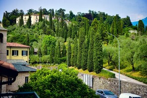 Un quartier résidentiel situé sur une colline, caractérisé par des murs en pierre et une végétation luxuriante.
