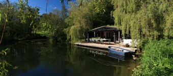 Sitting on the edge of a lake by itself.