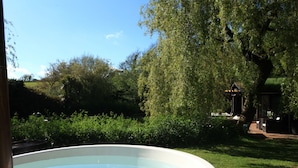 Une piscine entourée d’une végétation luxuriante et agrémentée d’un belvédère.