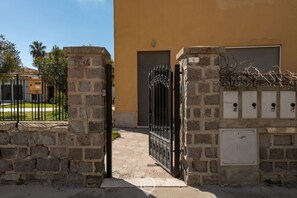 A building with a stone gate, a door, and a mailbox.