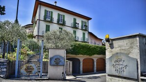 A building with a white facade, green shutters, and a balcony. - Green House Regatola by Wonderful Italy (Bellagio)