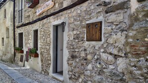 A stone building with a 'Welcome' sign, a wooden door, and flower boxes on the windowsills. - Ca de Sota by Wonderful Italy (Bellagio)