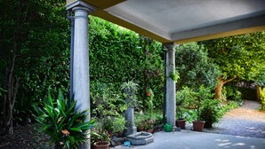 A covered garden area with potted plants and a gravel path. - Emilia Apartment by Wonderful Italy (Bellagio)