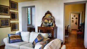 A living room with a beige sofa, a mirror, and framed pictures on the wall. - Emilia Apartment by Wonderful Italy (Bellagio)