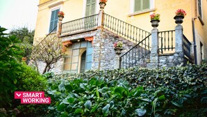 A building with a stone staircase, a balcony with green shutters, and potted plants. - Emilia Apartment by Wonderful Italy (Bellagio)