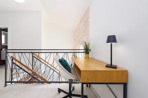A modern staircase with a metal railing, a wooden desk with a lamp, and a potted plant. - A Stunning Vacation Home in Vrsi—A Beachfront Getaway with a Private Saltwater Pool (Vrsi)