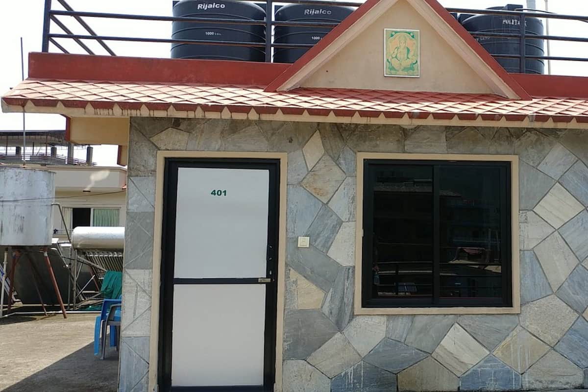 A small building with a tiled facade, a door labeled "401", and a window.