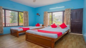 A room with two wooden beds, blue walls, and large windows with curtains. - MeroStay 020 Unique Mountain Guest House (Pokhara)